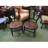 A pair of late Victorian hand painted black lacquered cane seat chairs with fretwork decoration on