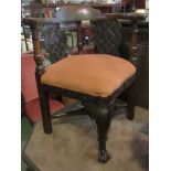 An 18th Century carved oak corner chair on turned and square legs joined by a turned 'X' stretcher