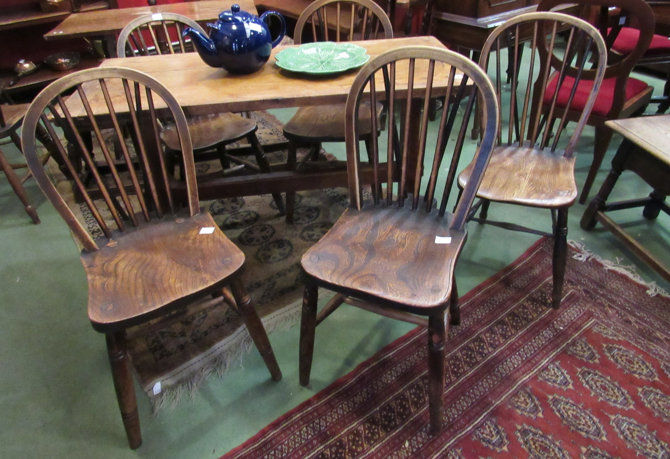 Five similar late 19th Century elm seated stick back chairs with V-support to backs and 'H'