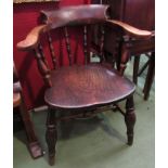 A late 19th/early 20th Century captains smokers bow chair with spindle back,