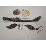 A silver and marcasite bracelet and a pair of feather-shaped earrings.
