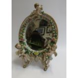 A ceramic free-standing mirror with cherub detail