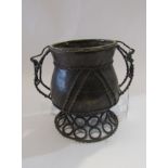 An African bronze vessel with twin handles supported on a ringed base, 15cm tall,