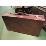 A heavy brown grained leather suitcase (66 x 37 x 14cm), metal label "KM Hickman,