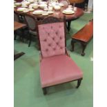 An Edwardian walnut button back open armchair with carved decoration over turned legs and ceramic