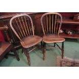 A pair of late 19th Century stick back elm seated chairs with sunken seats,