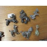 Eleven silver coloured poodle brooches including marcasite