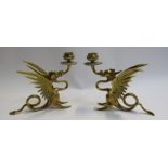 A pair of brass dragon form candlesticks