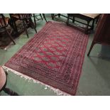 A red ground rug with geometric borders,