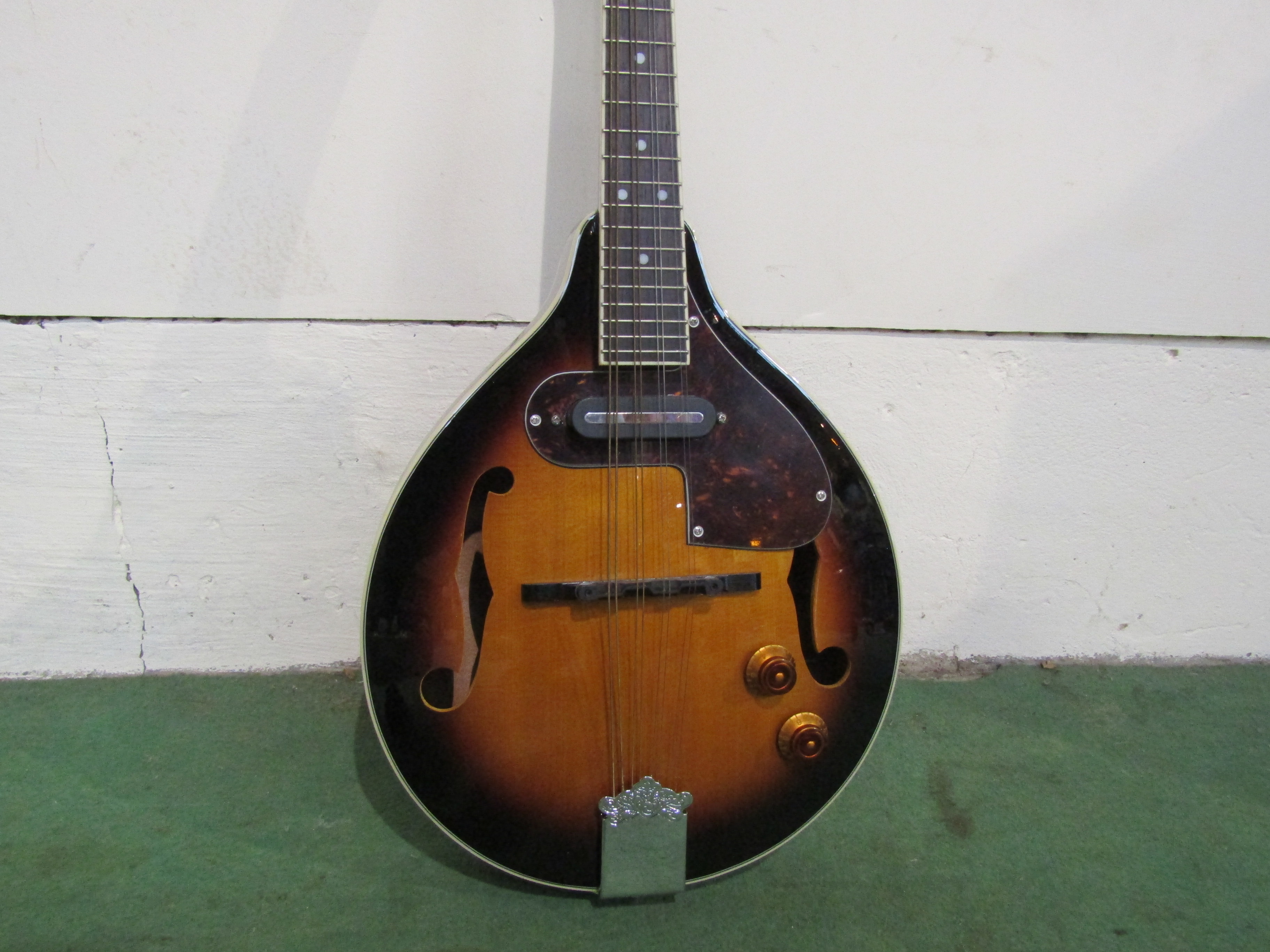 A Countryman mandolin of teardrop form, sunburst body with pickup and tortoiseshell pickguard,