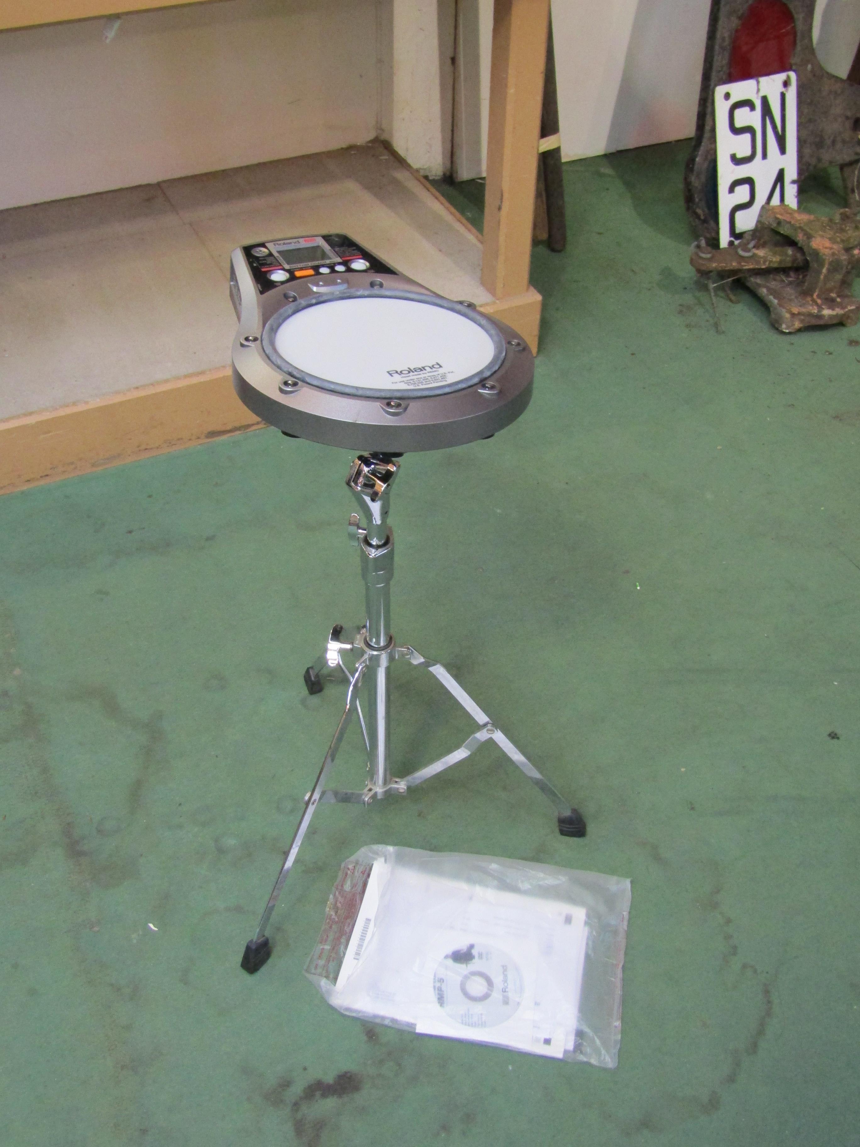 A Roland RMP-5 Rhythm Coach electronic drum pad on stand