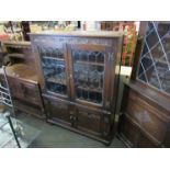 An Old Charm style oak lead glazed four door cabinet with linen fold panels,
