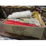 A box containing a quantity of upholstery and curtain fabric including velvet,