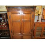 In the manner of Titchmarsh & Goodwin a 17th Century style panelled oak two door wardobe with