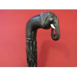 An African carved ebony walking stick with elephant head handle.