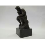 A bronze desk top figure of a nude gentleman sat on a rock thinking, mounted on a marble plinth,