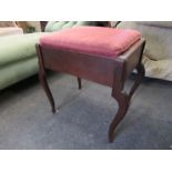 An Arts & Crafts oak piano stool with hinged seat and sheet music space over chamfered cabriole leg