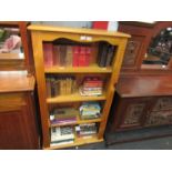 A modern pine bookcase with four shelves,