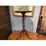 A Georgian style mahogany wine table the dished circular top on turned and fluted column over a