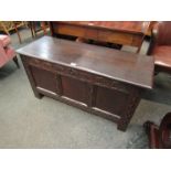 A circa 1760 oak three panel coffer with carved decoration and internal candle box over stile feet,