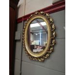 A gilt oval mirror with pierced border,