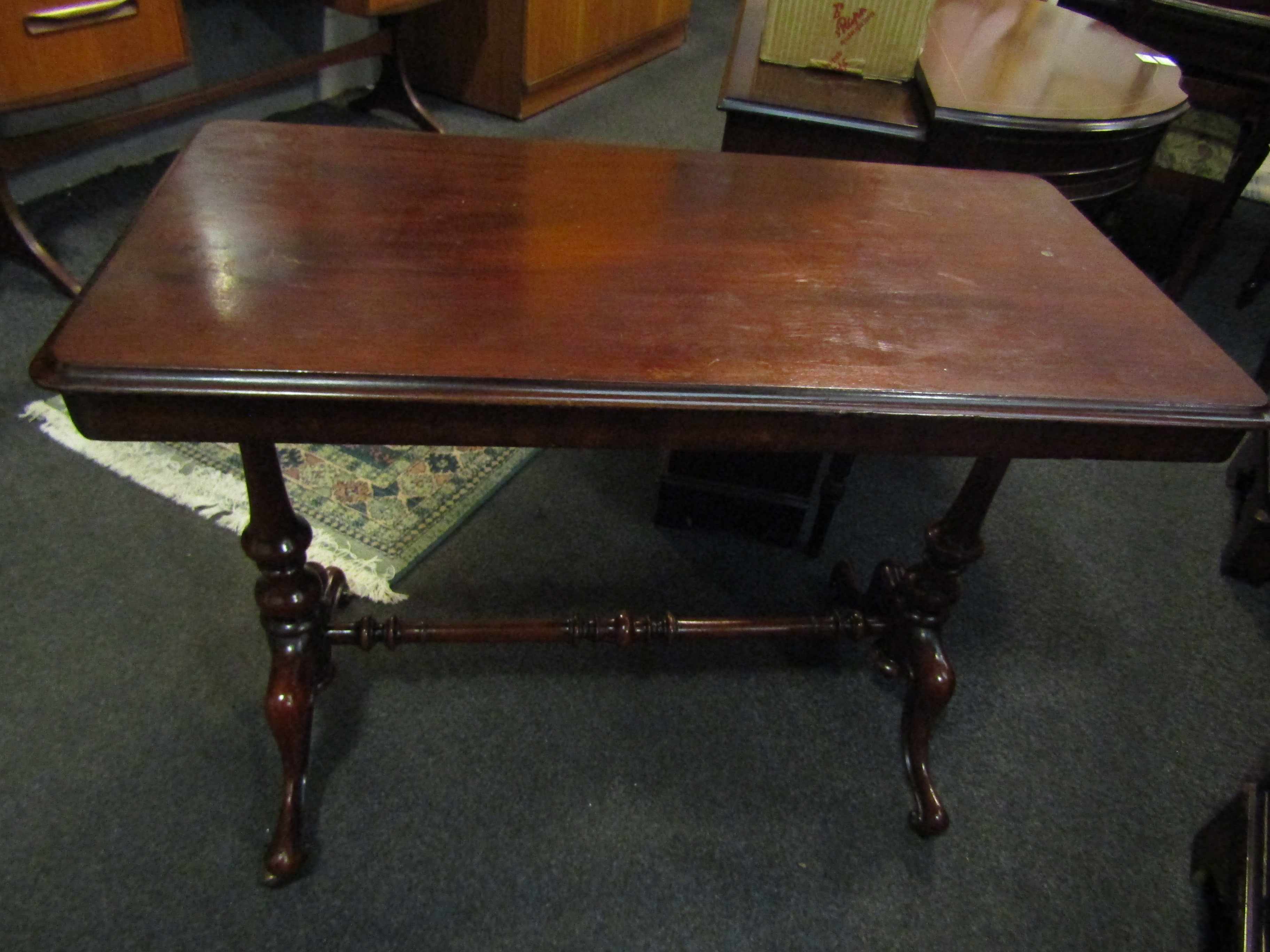 A Victorian mahogany stretcher table with brass castors and turned supports,