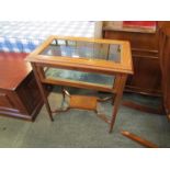 An Edwardian crossbanded mahogany bijouterie table the hinged top over square tapering legs joined