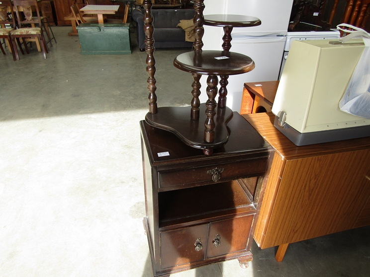 A wooden three tier plant stand and an oak bedisde cabinet