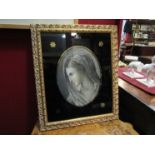 A 19th Century portrait veiled lady reverse painted, black border and gilt frame, 33cm long,