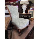An early Victorian walnut nursery open armchair with carved acanthus leaf scroll back rest over