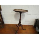 A Georgian style mahogany wine table the dished circular top on turned and fluted column over a