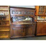 An early 20th Century Arts & Crafts sideboard with glazed two door top,