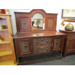 An oak sideboard with carved panel front and arched mirror back,