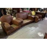 An Art Deco shaped faux leather upholstered settee suite, comprising two club armchairs and settee,