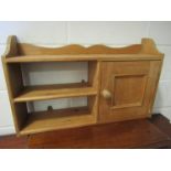 A pine wall hanging cupboard and shelf unit