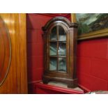 A George II style walnut dome top free standing corner cabinet the panel glazed door with key and