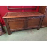 A 17th Century style panelled oak coffer with carved muntins over stile feet,