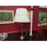 A brass effect table lamp with cream silk pinch pleated thread shade