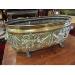 An antique brass planter with paw feet