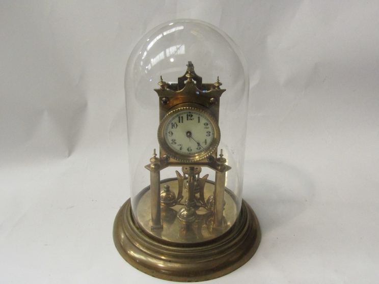 A Continental brass anniversary clock stamped DRGM 403658, with glass dome,