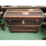 An Edwardian domed top luggage trunk with hard canvas body, wooden bound supports.