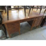 A 1950s oak seven drawer desk 76x136cm