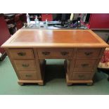 A circa 1900 satin walnut twin pedestal desk the tooled leather writing surface over seven drawers