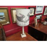 A painted lamp base with shade depicting hares,
