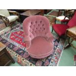 A Victorian walnut button back pink upholstered armchair on ring turned legs and castors