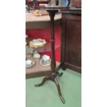 A George III style mahogany candle stand the dished circular top on a turned column and tripod base,