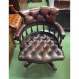 A Georgian style deep button leather captains revolving chair with metal stud decoration
