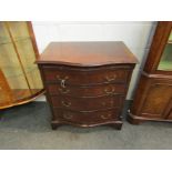 A circa 1930 small serpentine chest of four drawers with slide,