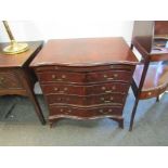 A 20th Century serpentine chest of four drawers with brushing slide,