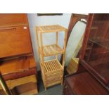 A bathroom unit with three shelves and cupboard,